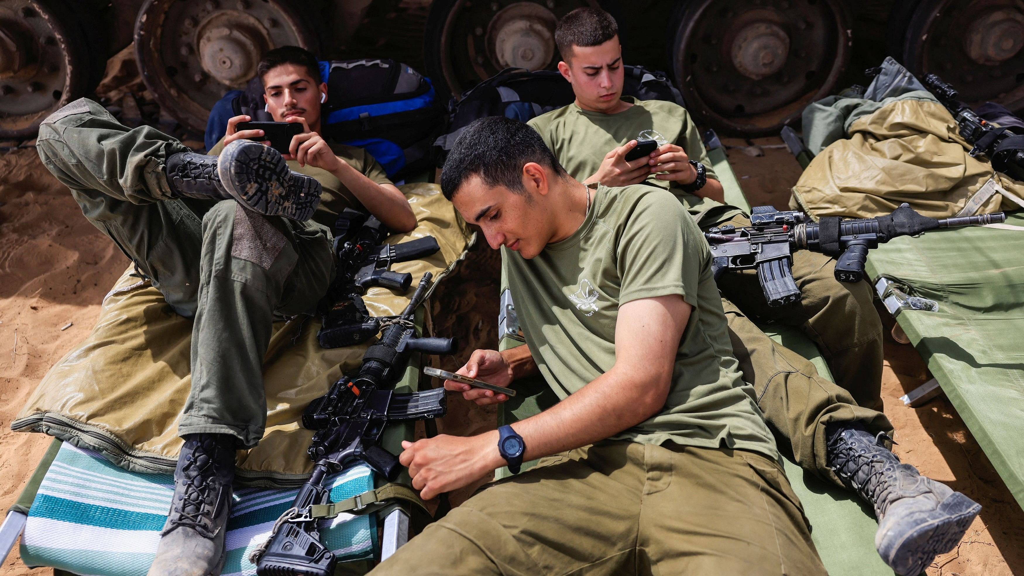 <div class="paragraphs"><p>Israeli soldiers rest outside the border with southern Gaza, amid the ongoing conflict between Israel and Hamas.</p></div>