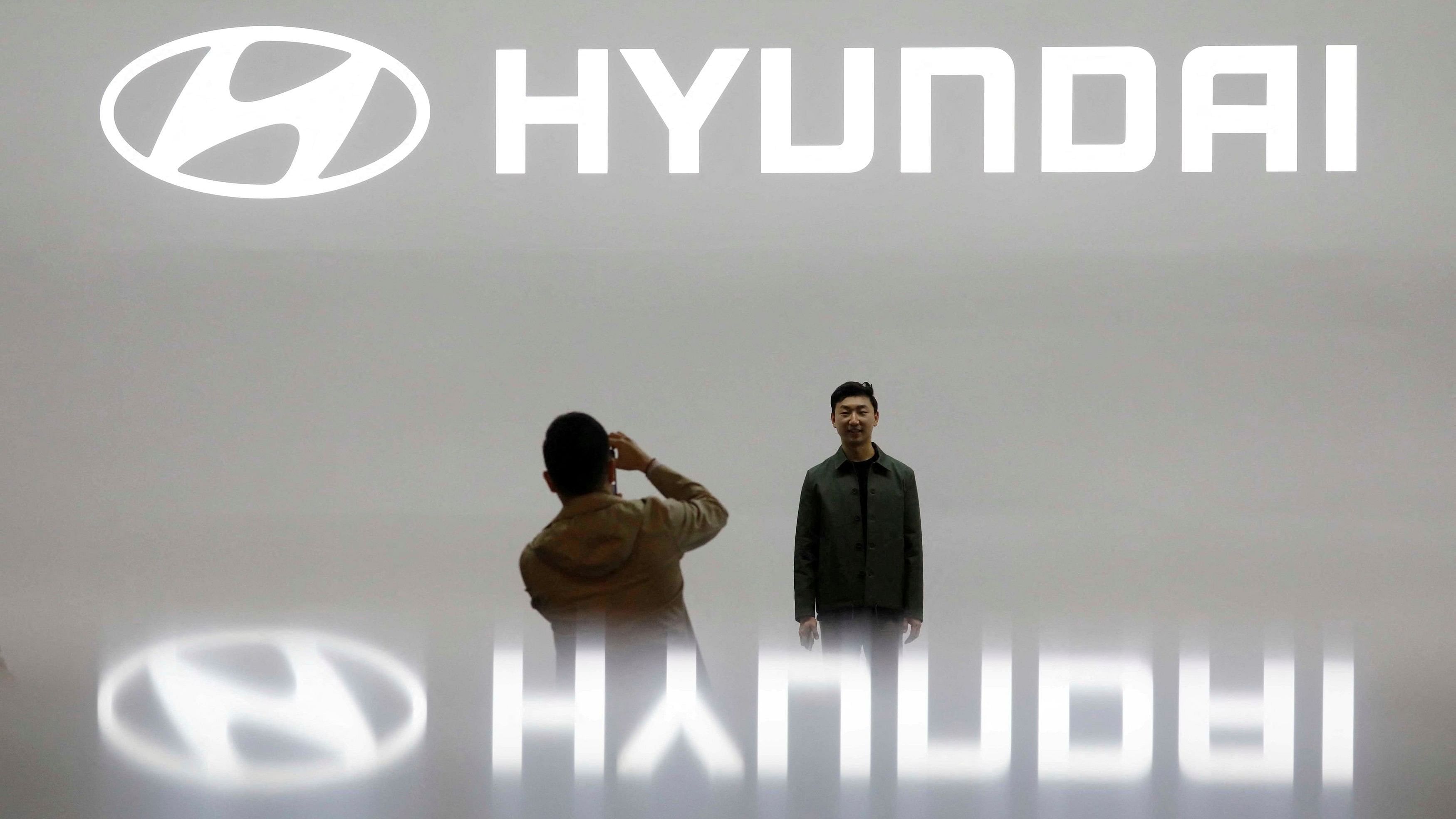 FILE PHOTO: Visitors take photographs in front of the logo of Hyundai Motor during the 2019 Seoul Motor Show in Goyang, South Korea, March 28, 2019. REUTERS/Kim Hong-Ji/File Photo