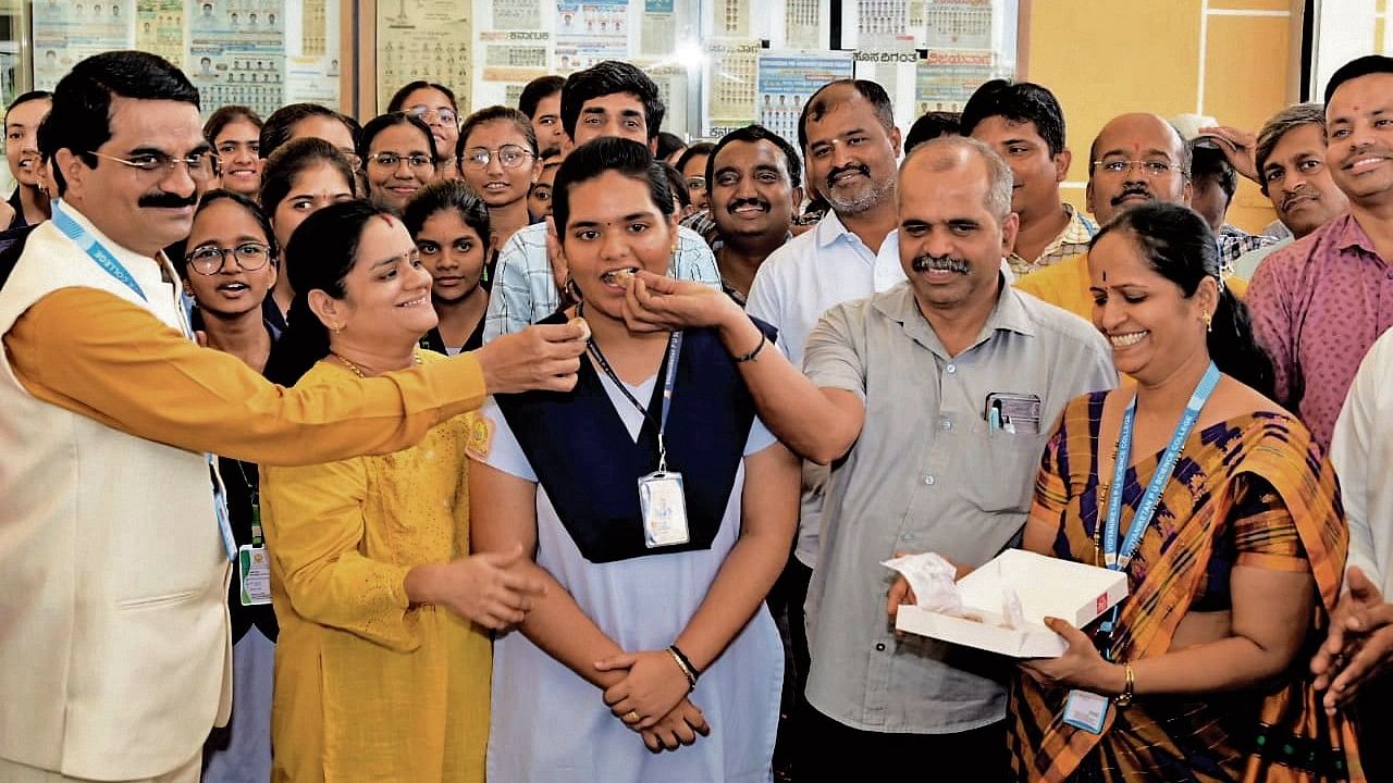 <div class="paragraphs"><p>A Vidyalakshmi, who topped the state in the science stream in the II PU exams, is offered sweets at Vidyaniketan PU Science College in Hubballi on Wednesday.&nbsp;</p></div>