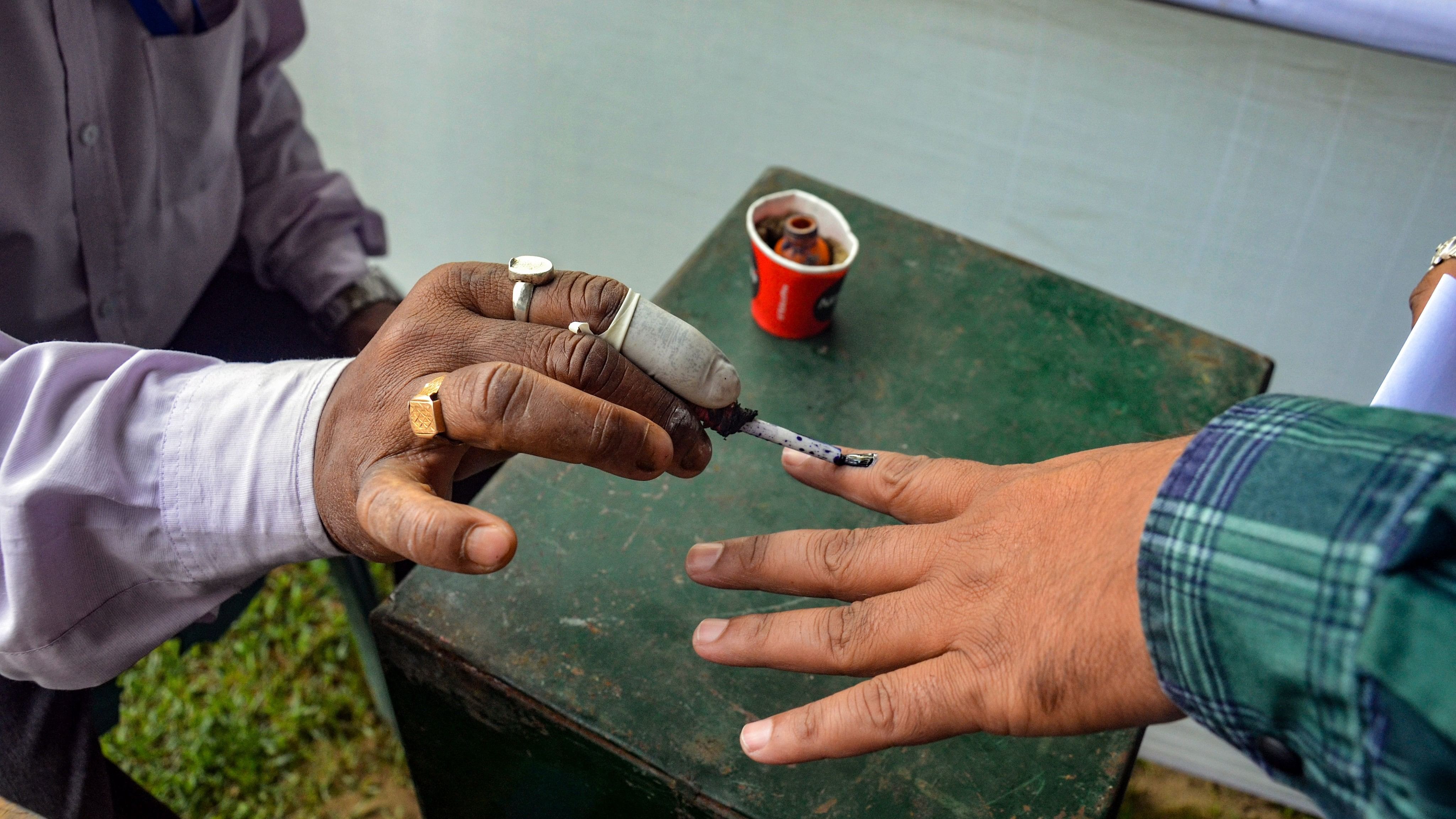 <div class="paragraphs"><p>An election official marks the finger of a polling official with indelible ink, who casts his vote through postal ballot for the Lok Sabha elections. Representative image.</p></div>