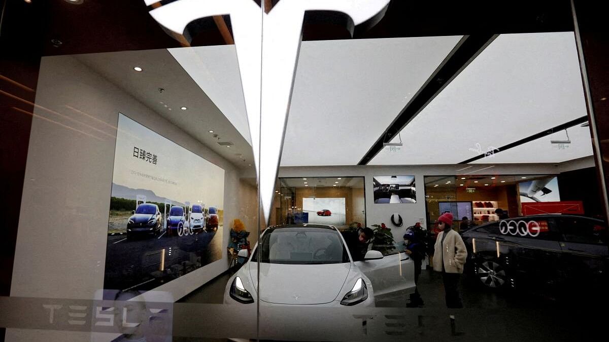 <div class="paragraphs"><p>In this file image, visitors check a Tesla Model 3 car next to a Model Y displayed at a showroom of the US electric vehicle maker in Beijing, China.</p></div>