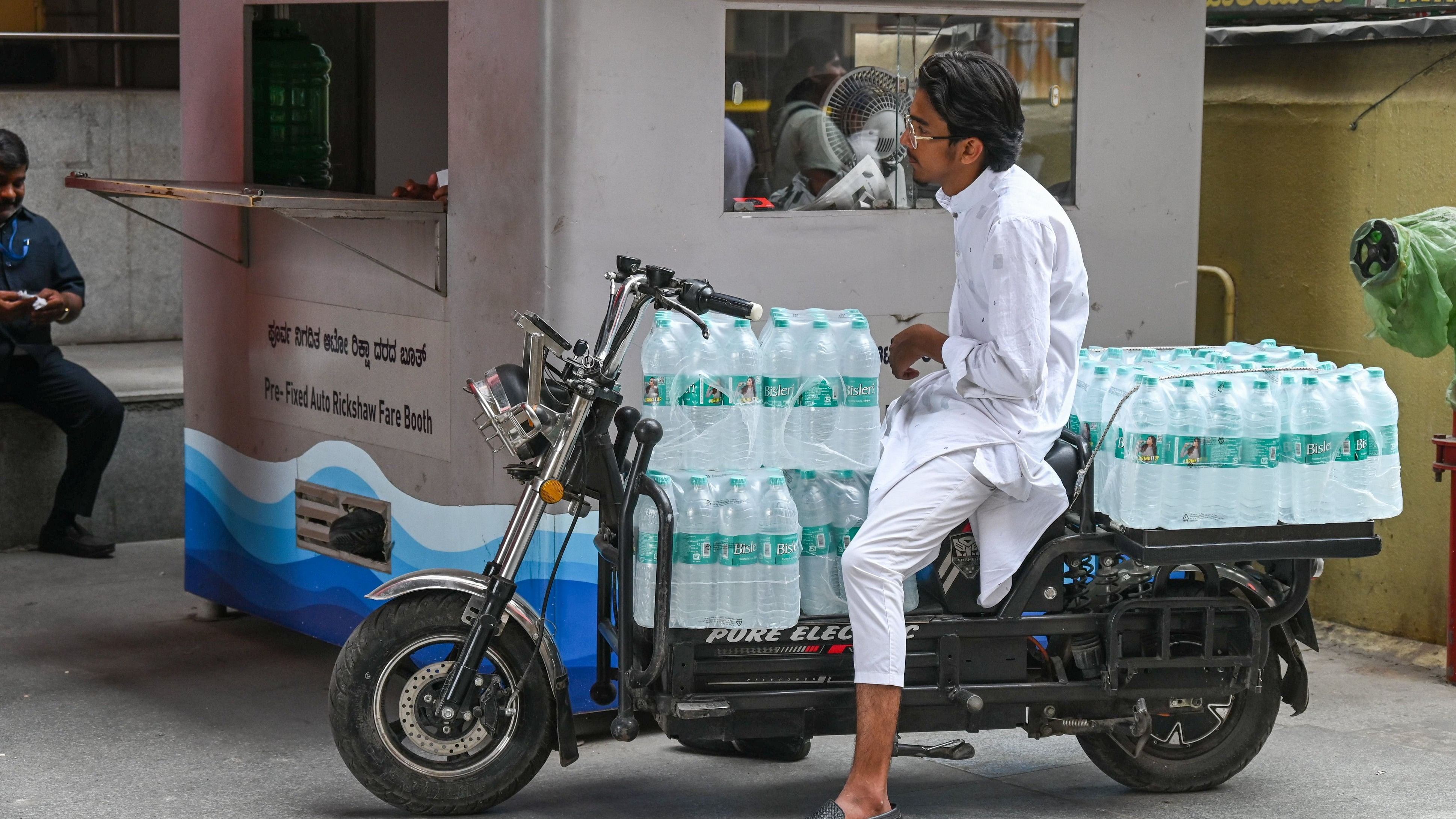 <div class="paragraphs"><p>A man distributes drinking water bottles at shops along MG Road Metro station to help people combat the summer heat. </p></div>