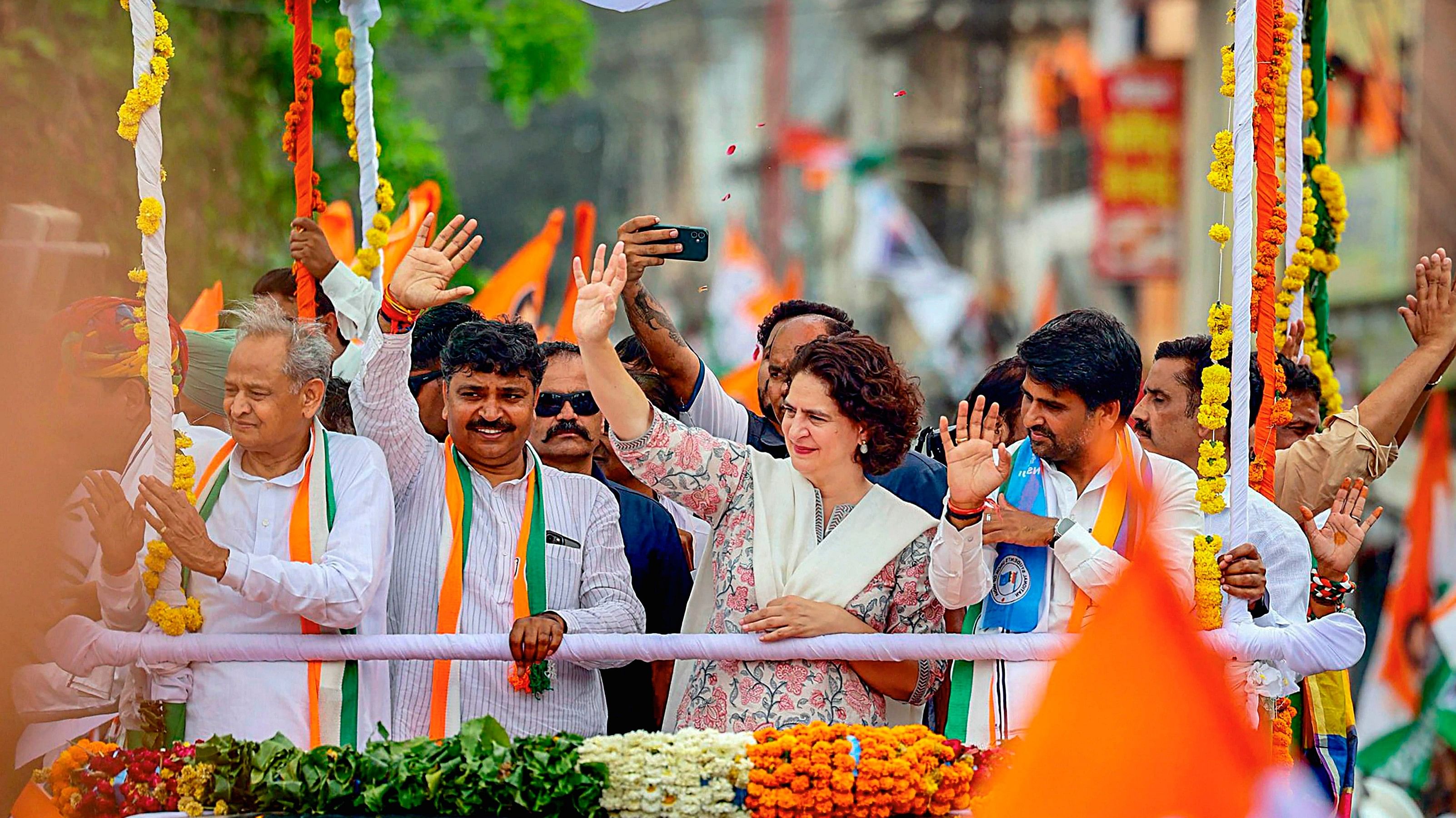 <div class="paragraphs"><p>Congress leaders Priyanka Gandhi Vadra and Ashok Gehlot wave at supporters at an election campaign rally in Alwar.</p></div>
