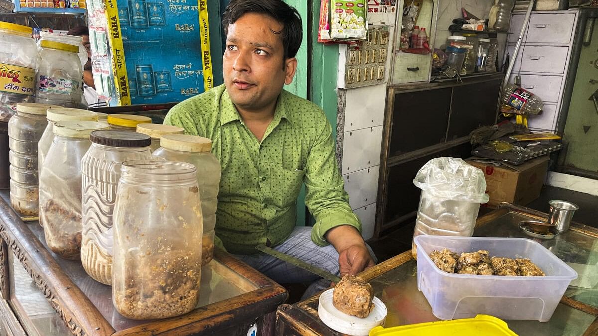 <div class="paragraphs"><p> Lalit Vashney, a hing trader, interacts with a customer in Hathras. </p></div>