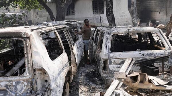 <div class="paragraphs"><p>A man looks at the charred remains of vehicles after they were set on fire by gangs, in Port-au-Prince.</p></div>