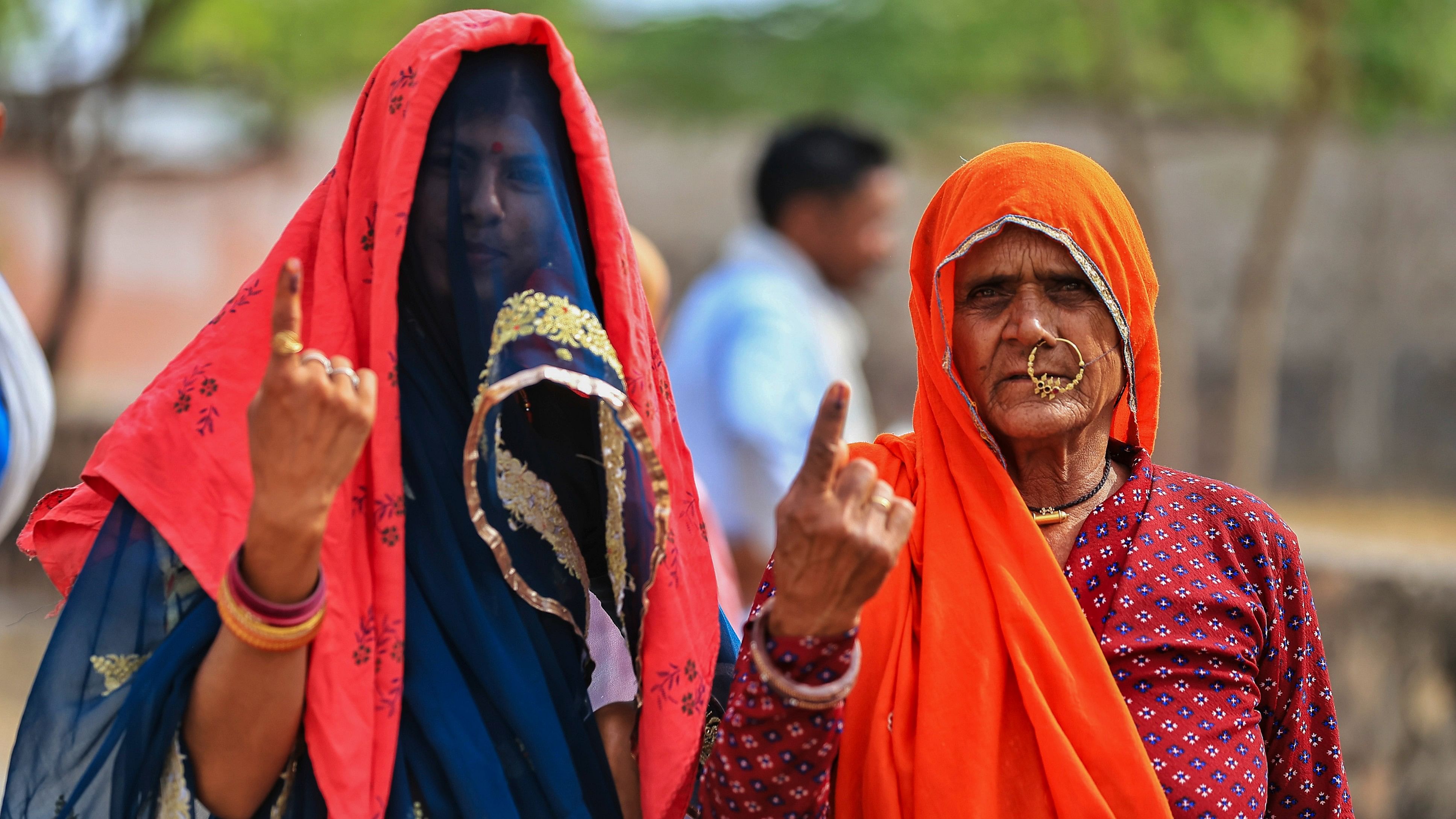 <div class="paragraphs"><p>Women voters show their fingers marked with indelible ink after casting votes during the second phase of Lok Sabha elections, in Dudu district, on Friday.</p></div>