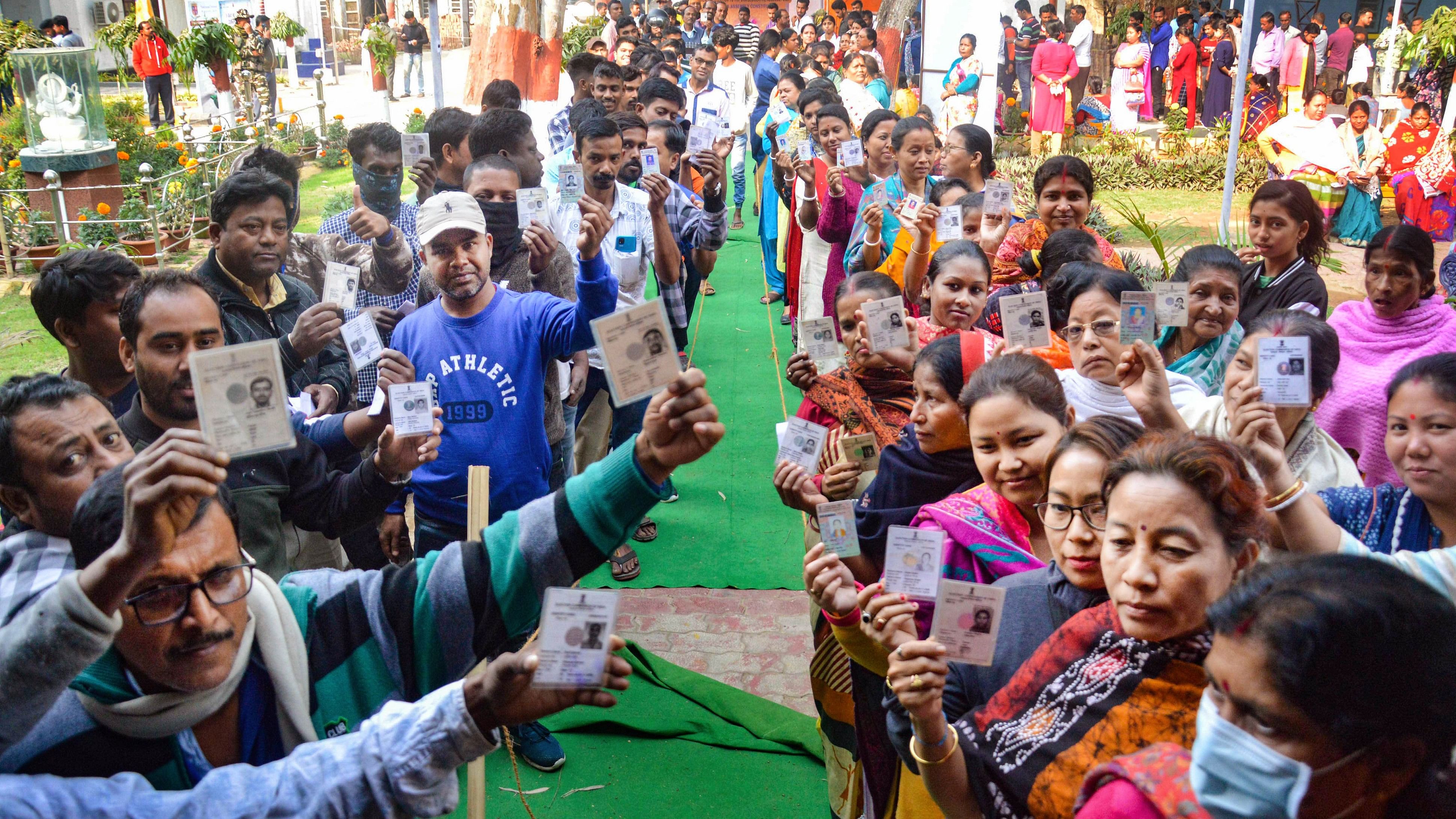 <div class="paragraphs"><p>Voters show their identification cards as they wait in queues to cast their votes.</p></div>