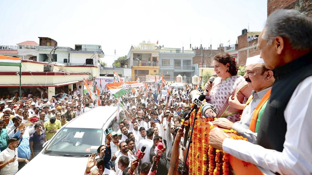 <div class="paragraphs"><p>Congress leader Priyanka Gandhi Vadra with former Rajasthan chief minister Ashok Gehlot addresses supporters during a roadshow before the nomination filing of the party candidate from Amethi constituency Kishori Lal Sharma, ahead of the third phase of Lok Sabha elections, in Amethi district, Friday, May 3, 2024.</p></div>