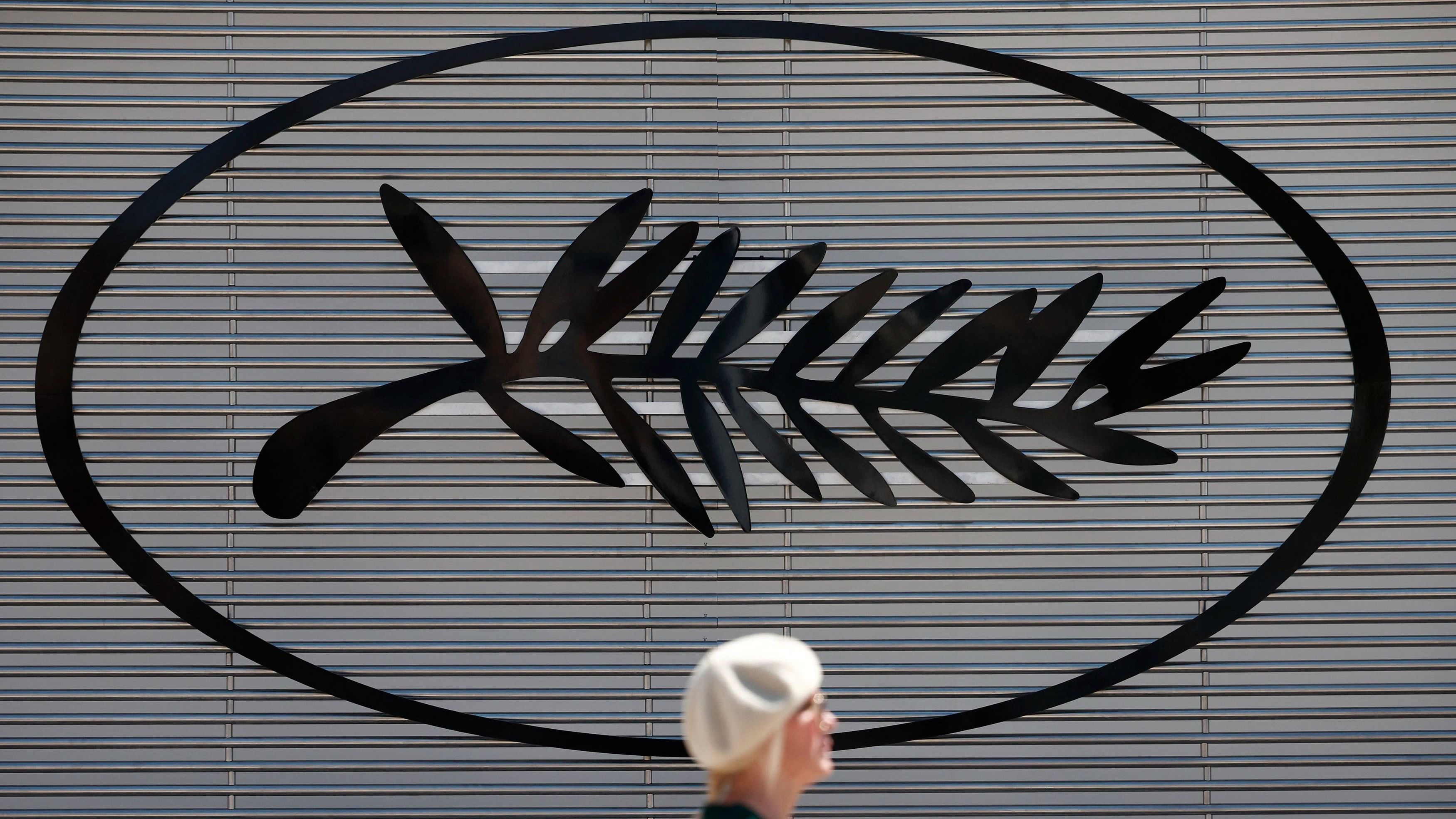 <div class="paragraphs"><p>A woman walks past a Palme d'Or symbol on the eve of the opening of the 77th Cannes Film Festival in Cannes, France, May 13, 2024.</p></div>