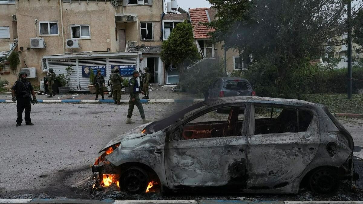 <div class="paragraphs"><p>Members of the Israeli Security forces stand next to a burning car at the impact site of a rocket that was fired towards Israel from Lebanon, amid ongoing cross-border hostilities between Hezbollah and Israeli forces, in Kiryat Shmona, northern Israel, May 10, 2024. ( Representative image)</p></div>