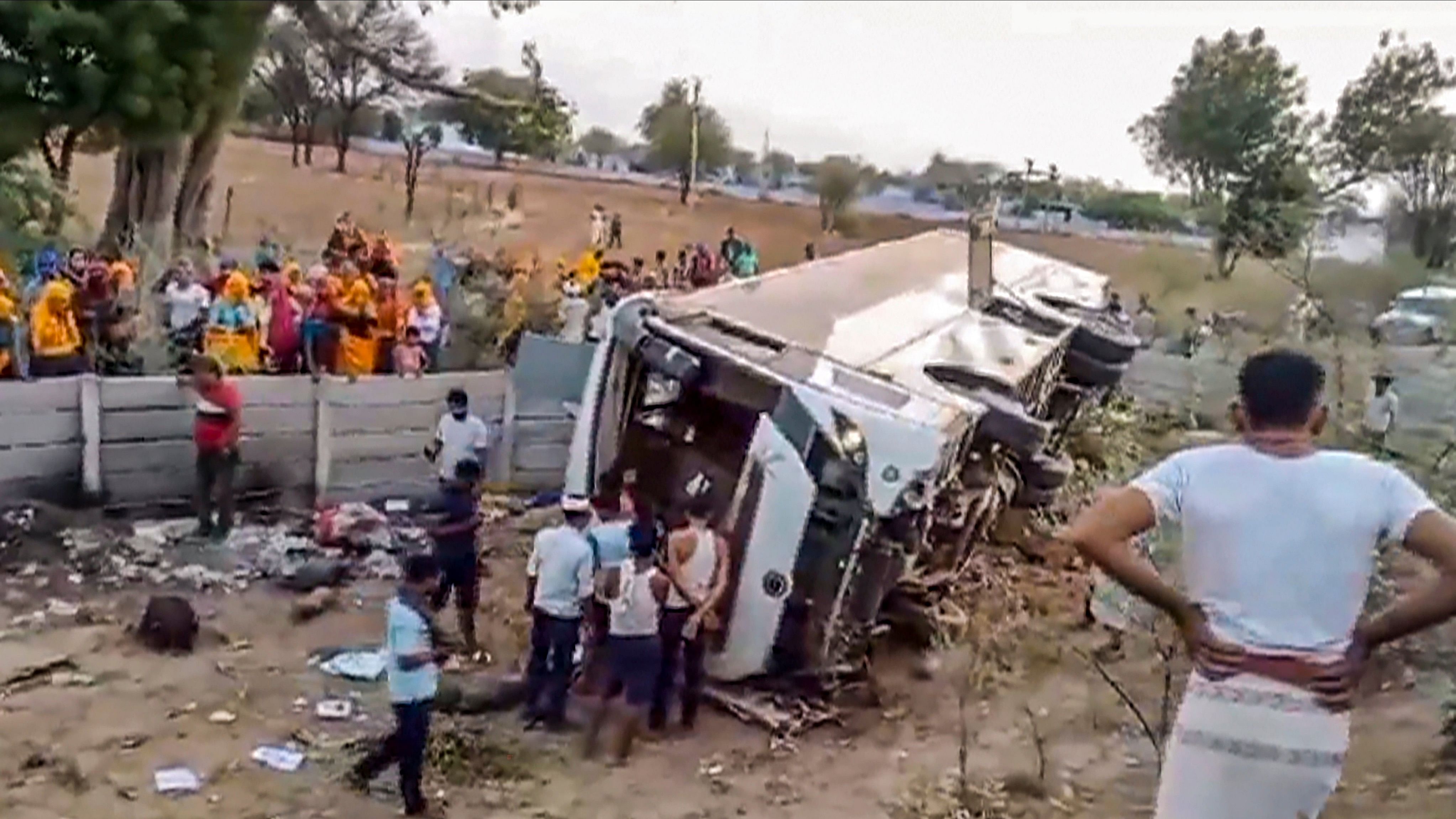 <div class="paragraphs"><p> Locals near the wreckage of a bus that overturned on Delhi-Mumbai expressway, near Dausa.</p></div>