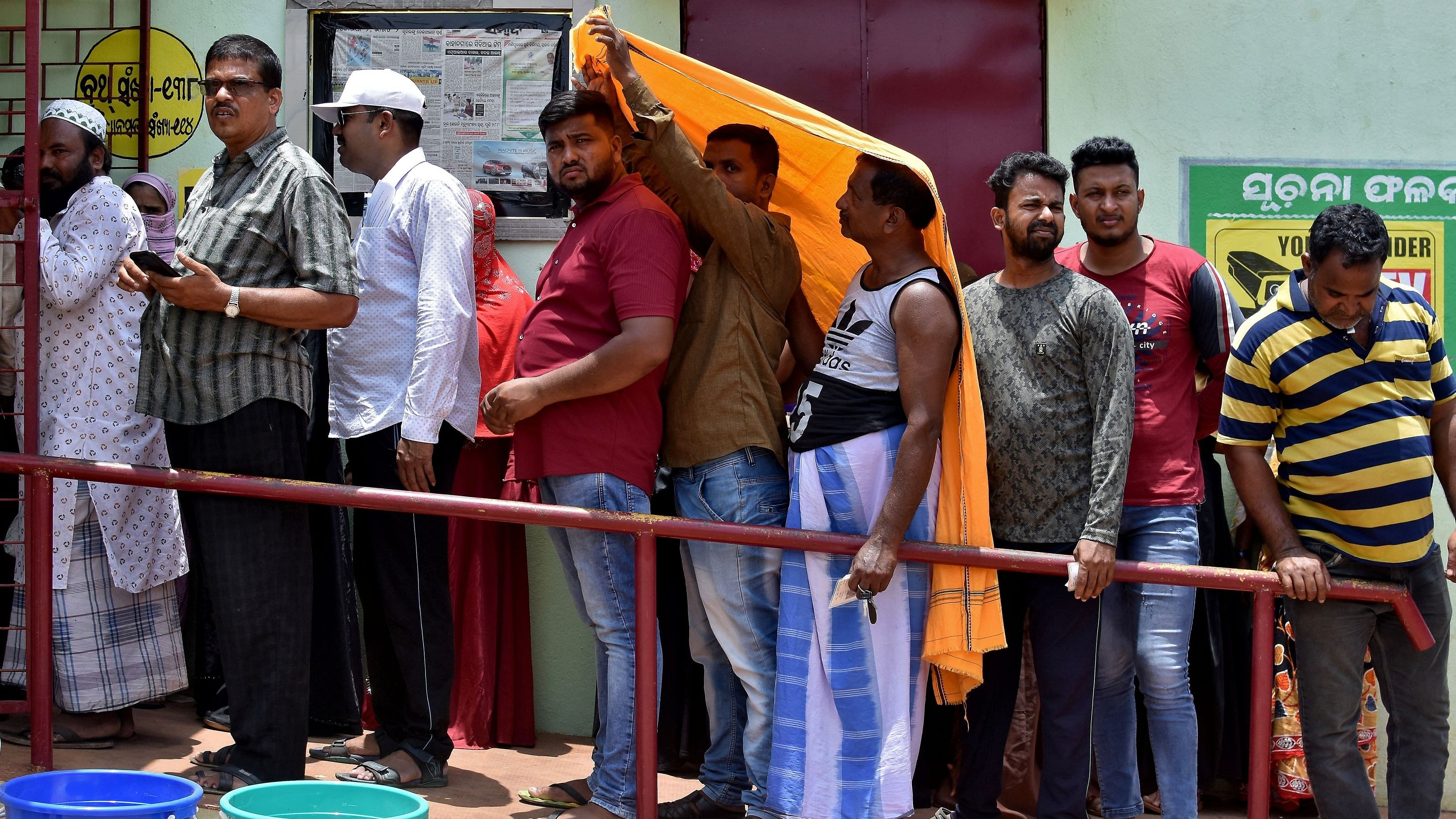 <div class="paragraphs"><p>Men use a stole to cover from heat as they wait in a line outside a polling station to cast their votes during the sixth phase of India's general election, on a hot summer day in Bhubaneswar, India.</p></div>