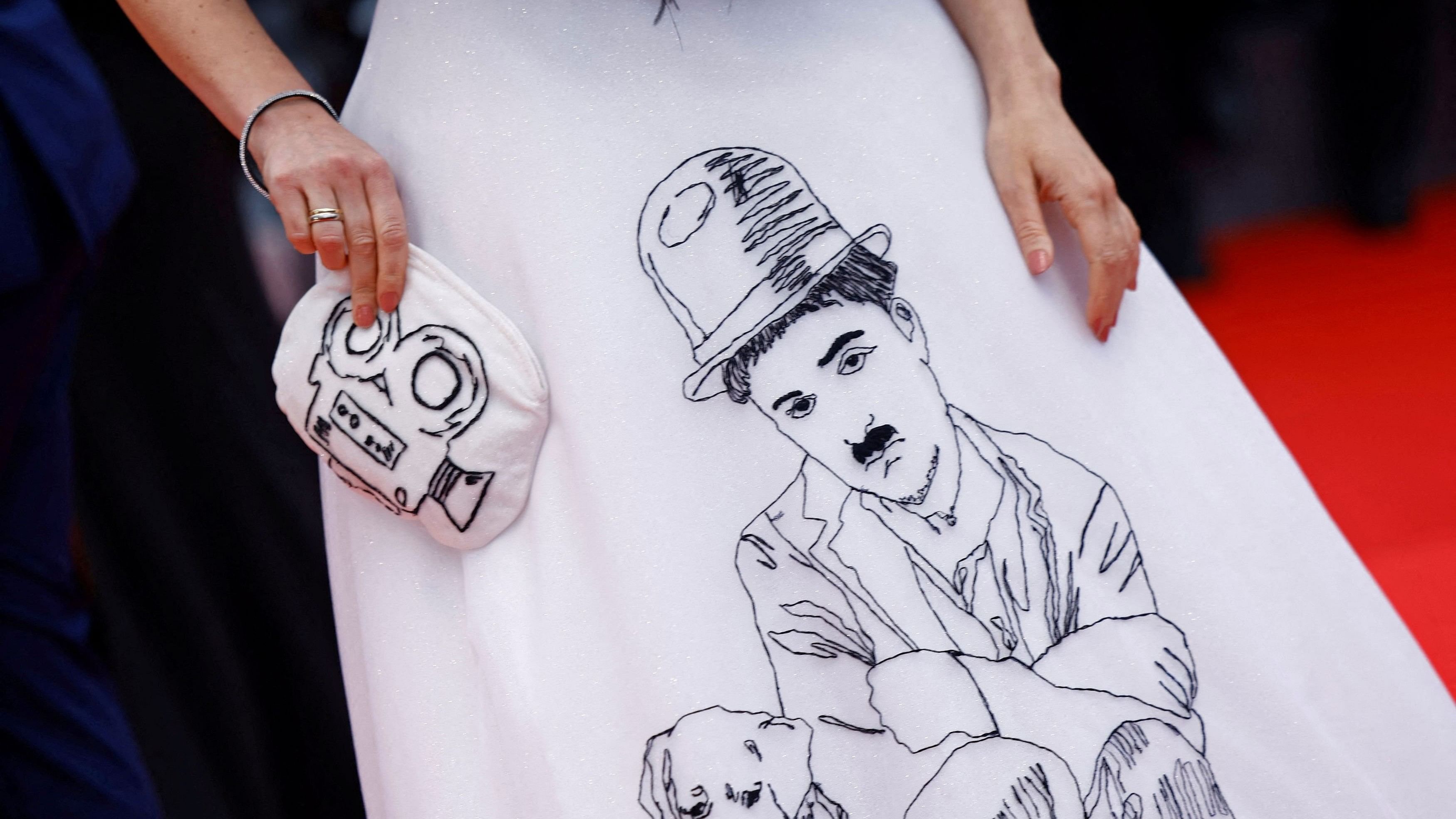 <div class="paragraphs"><p>Ilona Matsou wearing a dress with an image of Charlie Chaplin poses on the red carpet during arrivals for the opening ceremony and the screening the film "Le deuxieme acte" (The Second Act) Out of competition at the 77th Cannes Film Festival in Cannes, France.</p></div>