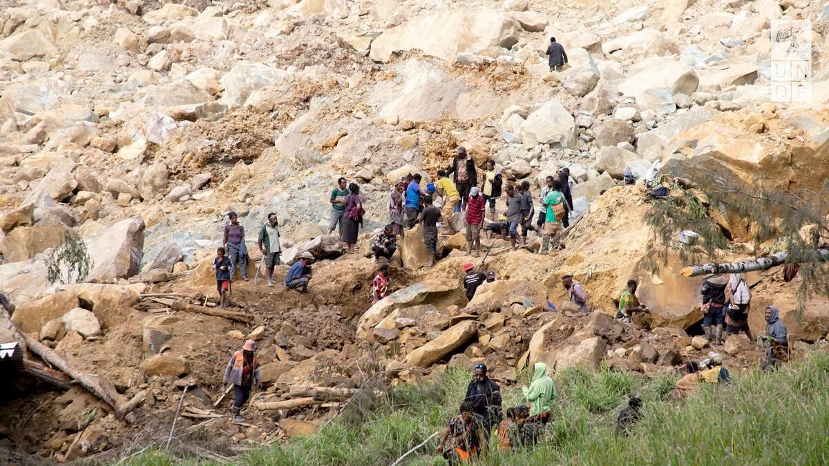 <div class="paragraphs"><p>People clear an area at the site of a landslide in Yambali village, Enga Province, Papua New Guinea</p></div>