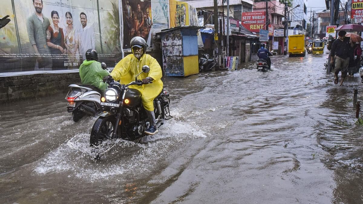 <div class="paragraphs"><p>Commuters wade through a flooded road amid rains, in Kochi, Wednesday, May 29, 2024. </p></div>