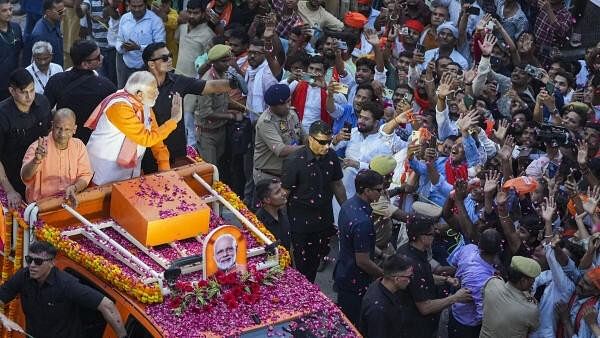 <div class="paragraphs"><p>Prime Minister Narendra Modi with Uttar Pradesh Chief Minister Yogi Adityanath during a road show for Lok Sabha elections, in Varanasi.</p></div>