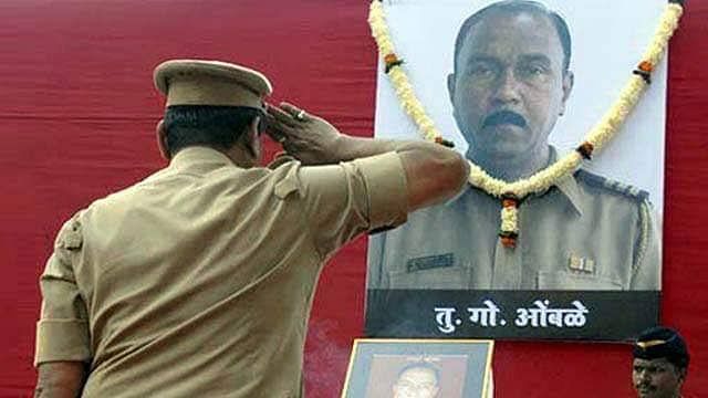 <div class="paragraphs"><p>A police officer salutes a portrait of former Maharashtra ATS chief Hemant Karkare, who was killed during the 2008 Mumbai terror attacks.</p></div>