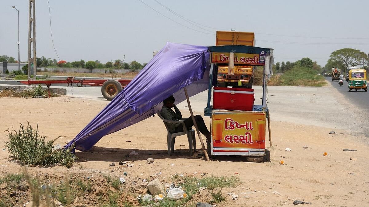 <div class="paragraphs"><p>A stallholder sits in the shade, waiting for customers on a hot summer day on the outskirts of Ahmedabad.</p></div>