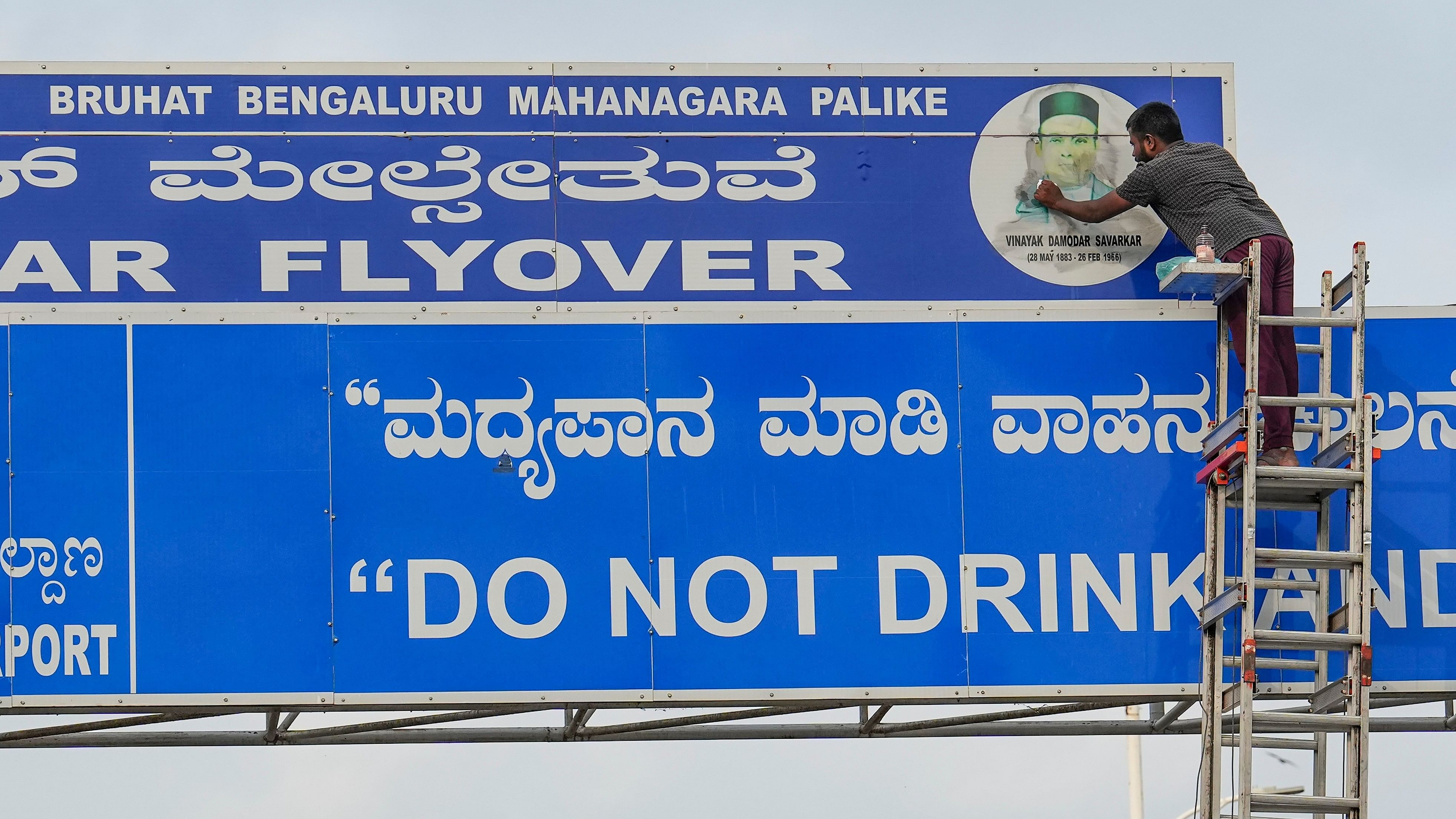 <div class="paragraphs"><p>Bengaluru: A worker cleans a signboard of Veer Savarkar Flyover after it was defaced with black ink by NSUI members, in Bengaluru, Tuesday, May 28, 2024. </p></div>