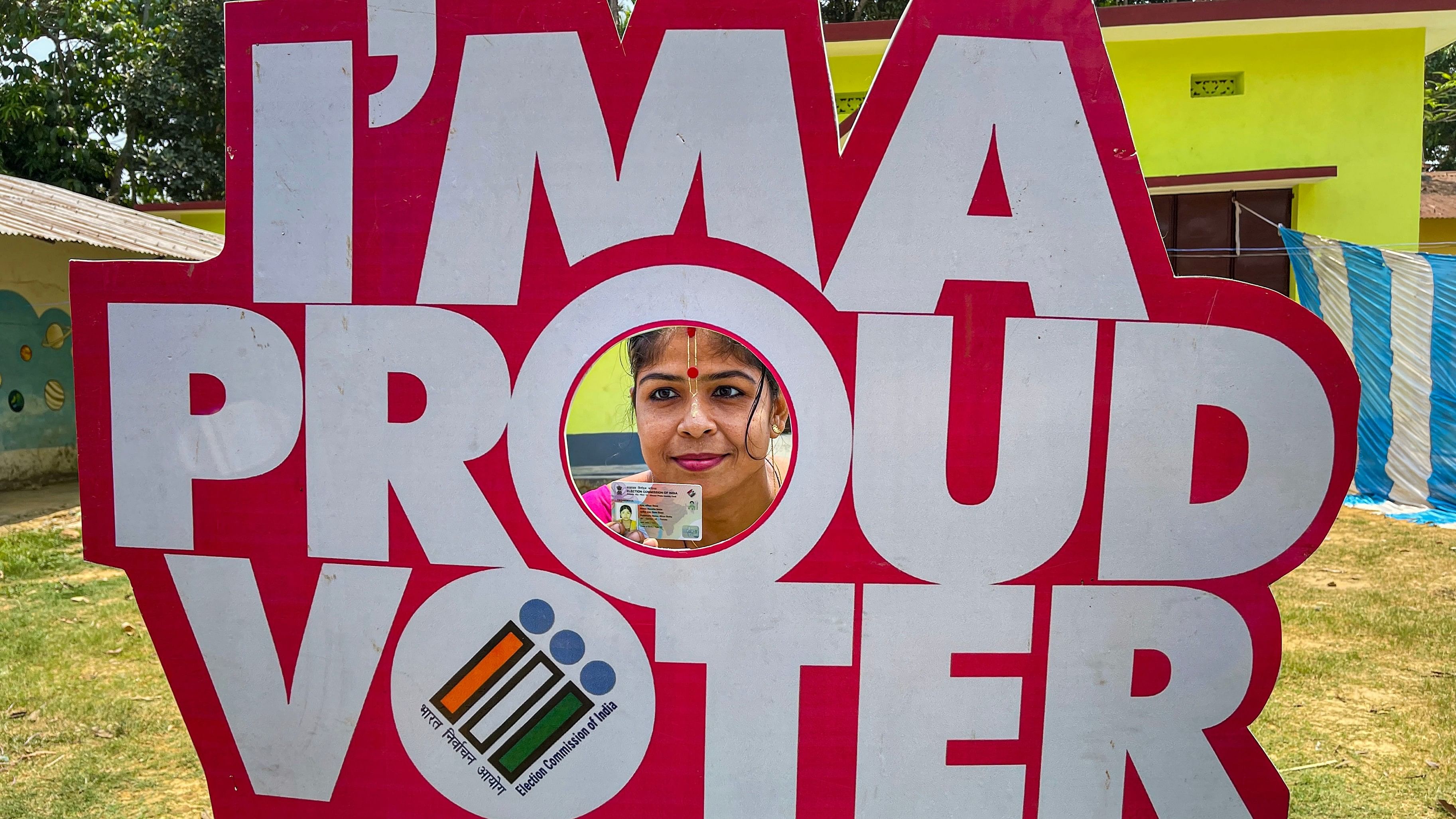 <div class="paragraphs"><p>A voter poses for photos at a polling booth on the day of voting.</p></div>