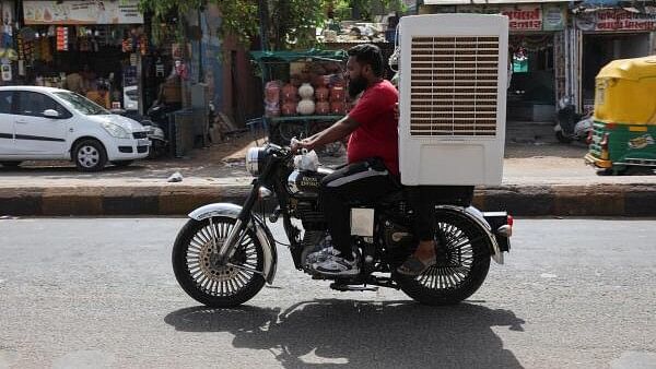 <div class="paragraphs"><p>A man transports an air cooler on a motorcycle during a heat wave in Ahmedabad.</p></div>