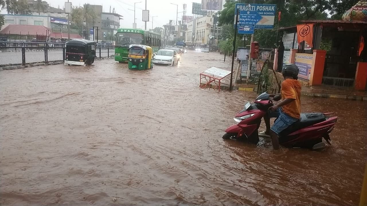 <div class="paragraphs"><p>Motorists struggle to navigate a flooded Vidyanagar road in Hubballi. The city witnessed heavy showers on Saturday evening.&nbsp;</p></div>