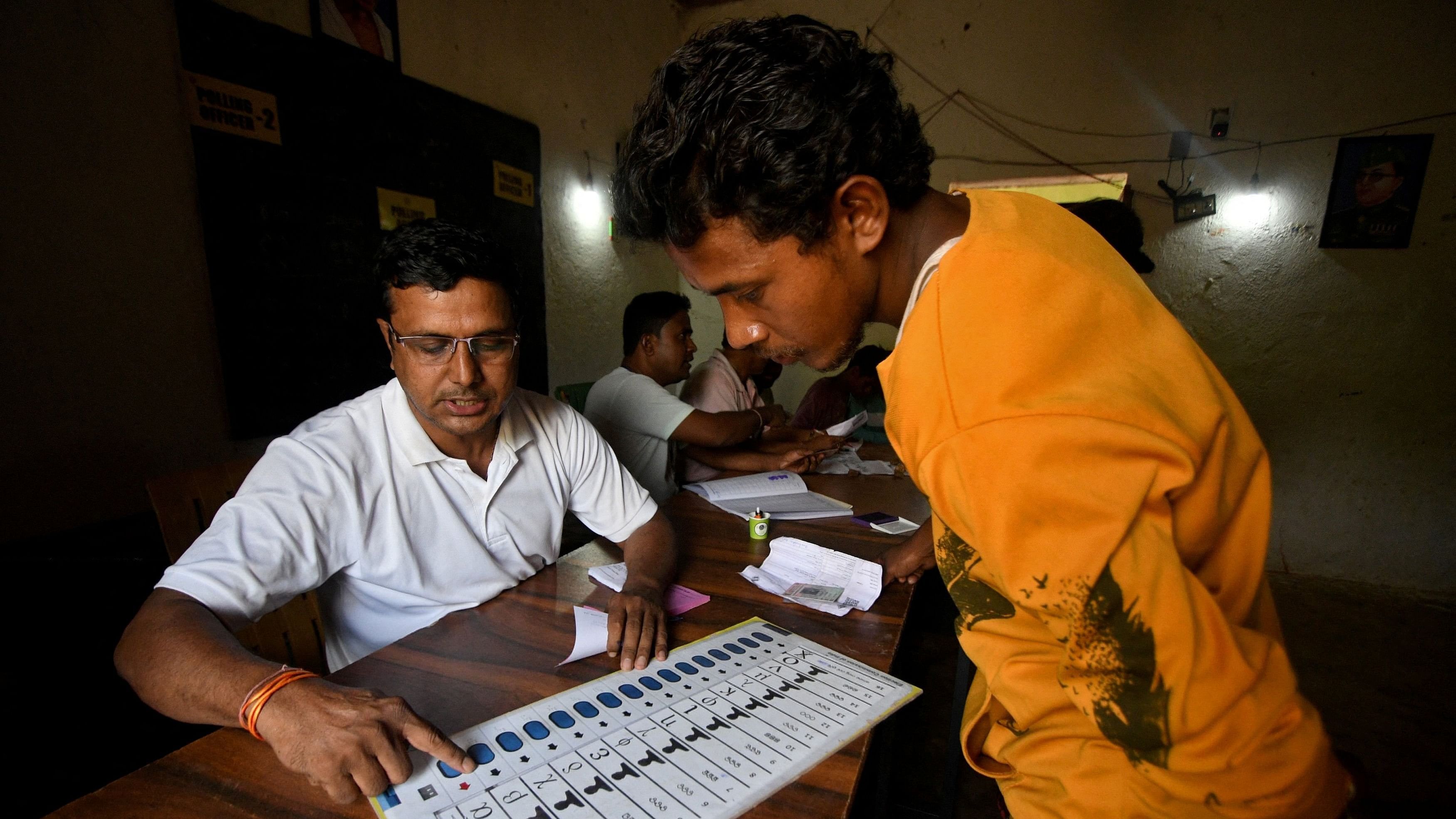 <div class="paragraphs"><p>An election official using a model of an Electronic Voting Machine  shows a voter how to vote at a polling station during the fourth phase of India's general election, in Malkangiri district in the eastern state of Odisha.</p></div>