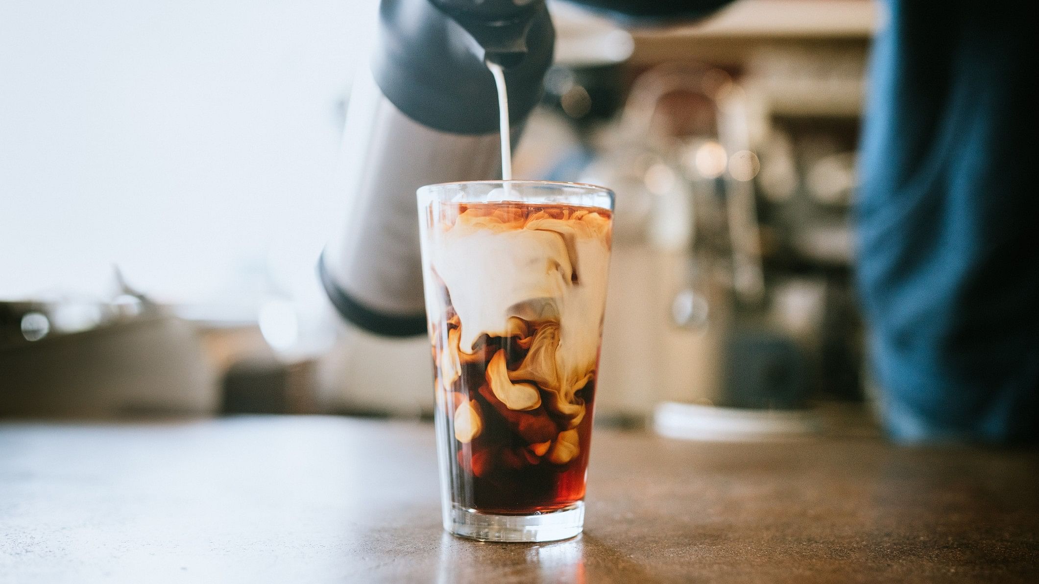 <div class="paragraphs"><p>A man pours cold whole milk in to a glass of iced coffee. (Representative image)</p></div>