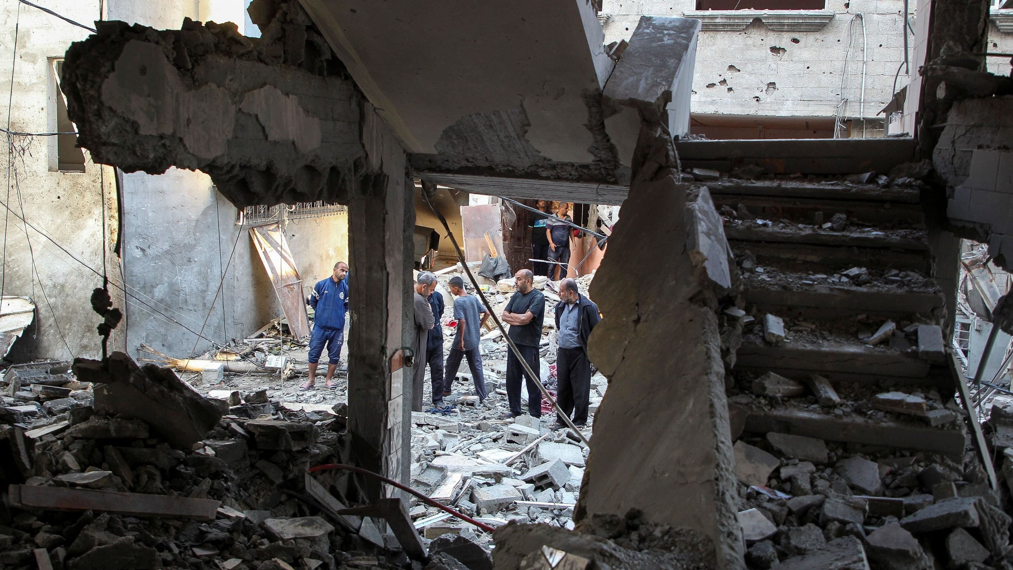 <div class="paragraphs"><p>Palestinians gather at the site of an Israeli strike on a house, amid the ongoing conflict between Israel and the Palestinian Islamist group Hamas, in Rafah.</p></div>