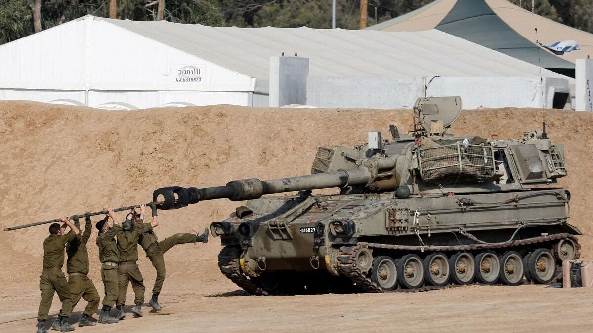 <div class="paragraphs"><p>Israeli soldiers clean the barrel of a mobile artillery unit, near the Israel-Gaza border</p></div>