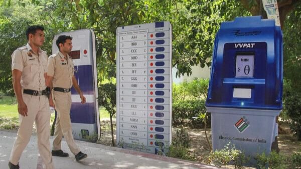 <div class="paragraphs"><p>Police personnel near standees of an Electronic Voting Machine (EVM) and VVPAT machine installed by the Election Commission of India (ECI) as part of the voter awareness campaign for the Lok Sabha polls, in Gurugram.</p></div>