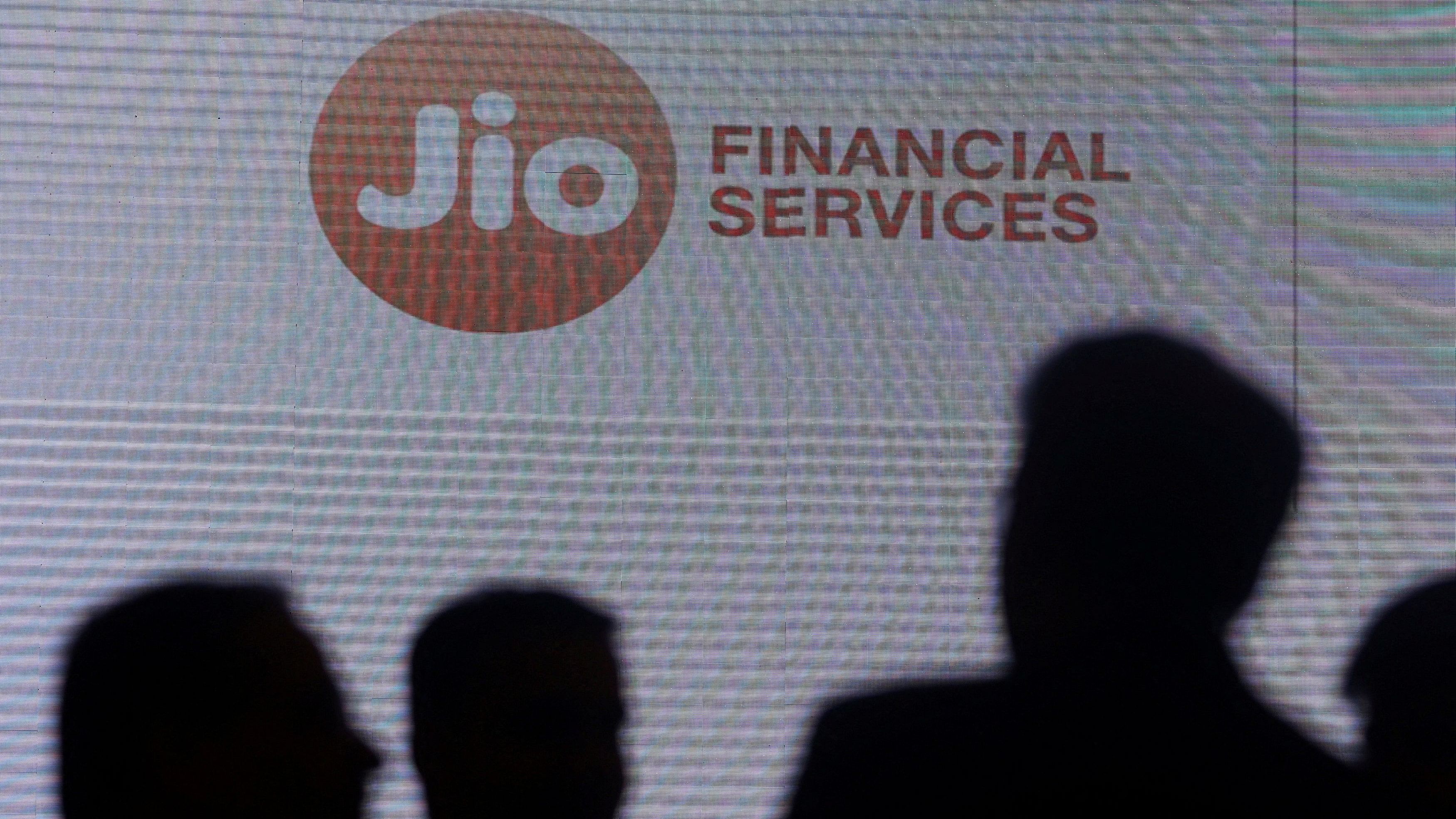 <div class="paragraphs"><p>People stand next to a logo of Jio Financial Services</p></div>