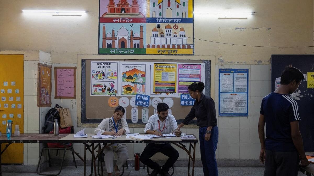 <div class="paragraphs"><p>A woman collects her voter slip before casting her vote at a polling station during the sixth phase of the general election, in New Delhi.</p></div>