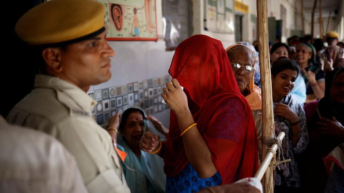 <div class="paragraphs"><p>A policeman stands guard as voters stand in lines to cast their votes at a polling station during the sixth phase of the general election, in New Delhi.</p></div>