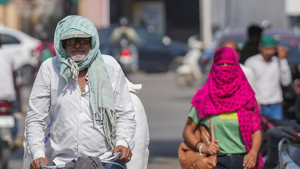 <div class="paragraphs"><p> A man covers his head with a scarf amid heatwave on a hot summer day.</p></div>