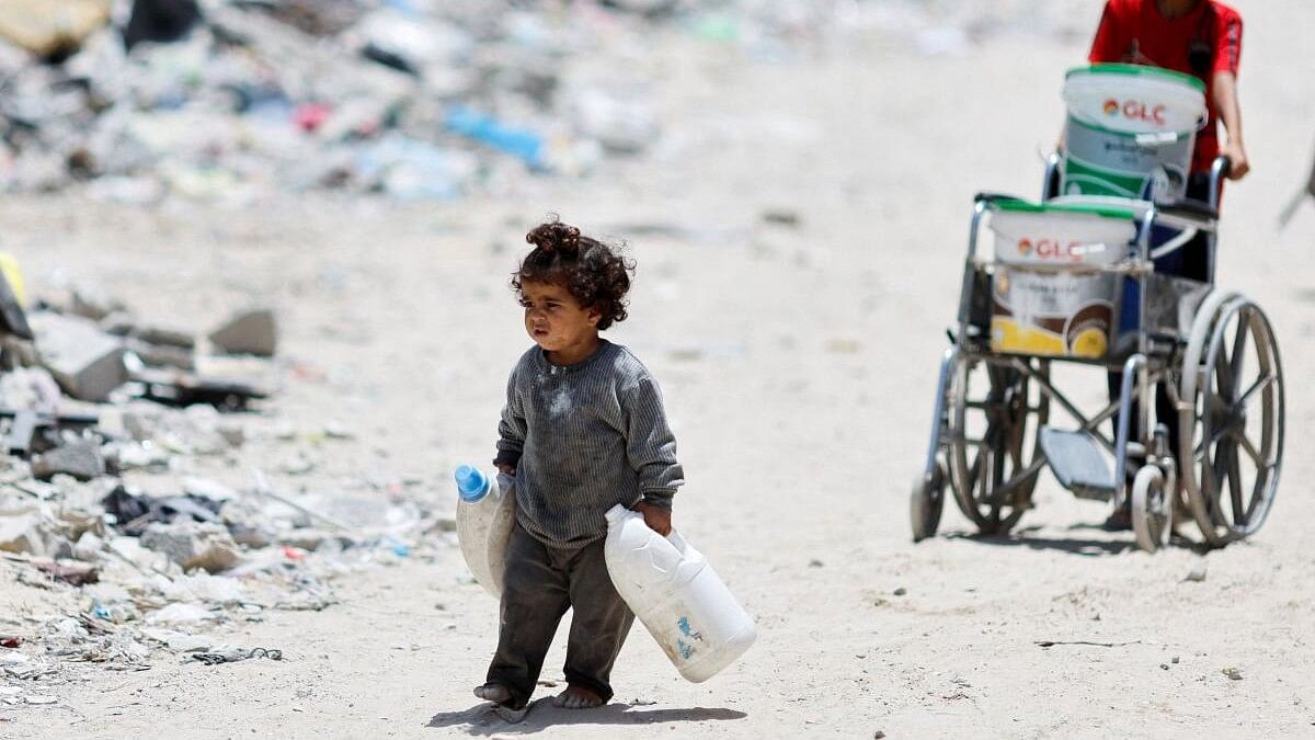 <div class="paragraphs"><p>A Palestinian girl carries cans to collect water as she walks by houses which were destroyed in an Israeli strike in the southern Gaza Strip.</p></div>