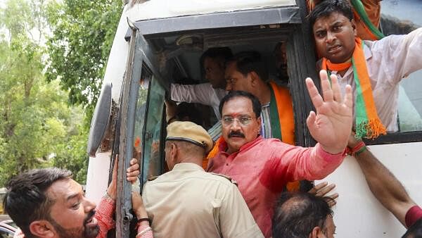 <div class="paragraphs"><p>Police personnel detain BJP Delhi President Virendra Sachdeva and other party workers during BJP's protest against jailed Delhi Chief Minister Arvind Kejriwal, in New Delhi, Tuesday, May 7</p></div>