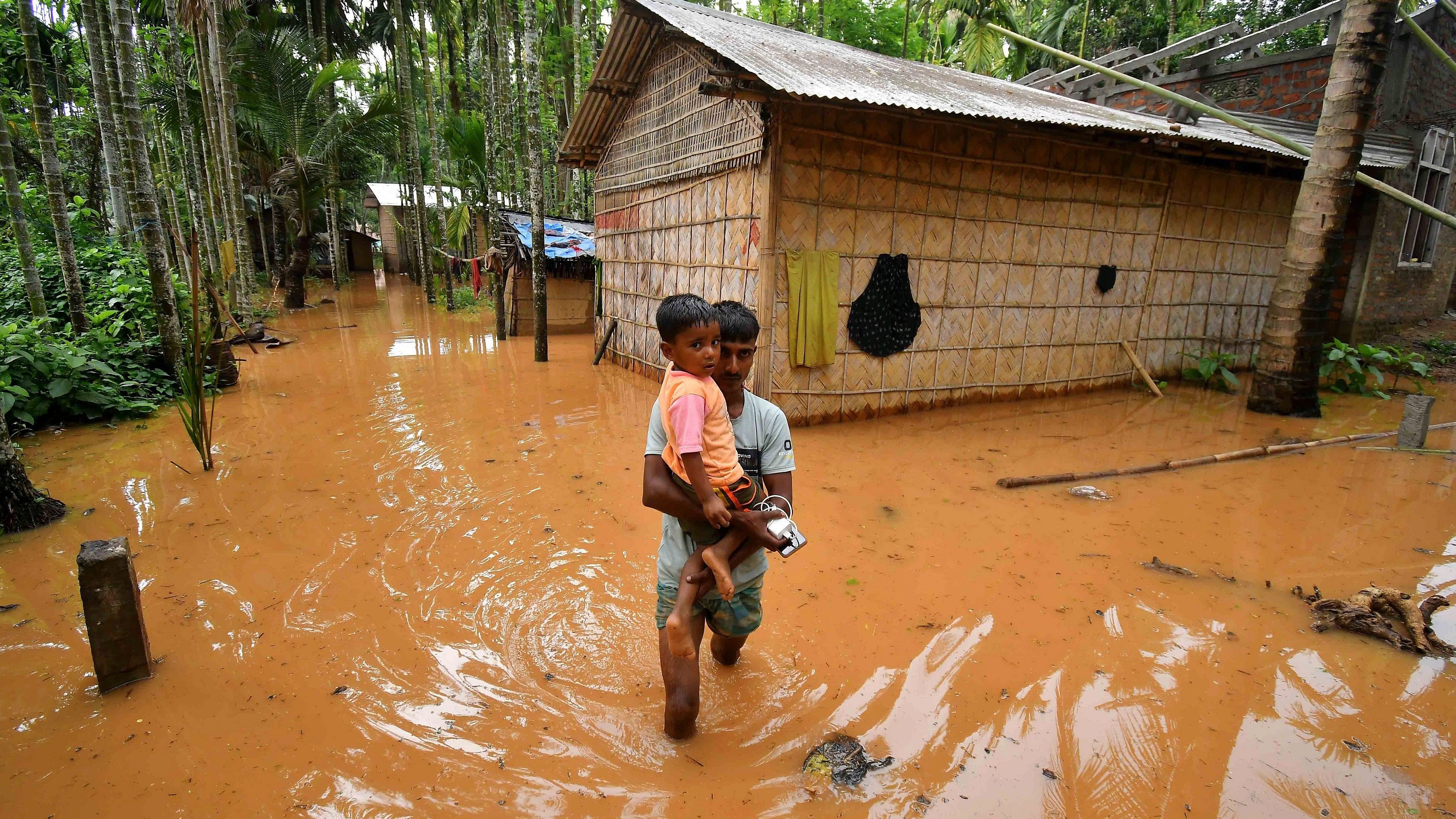<div class="paragraphs"><p> A man carries a child in a flooded village after heavy rains following the landfall of Cyclone Remal at Singi Mari near Kampur in Nagaon district of Assam.&nbsp;</p></div>