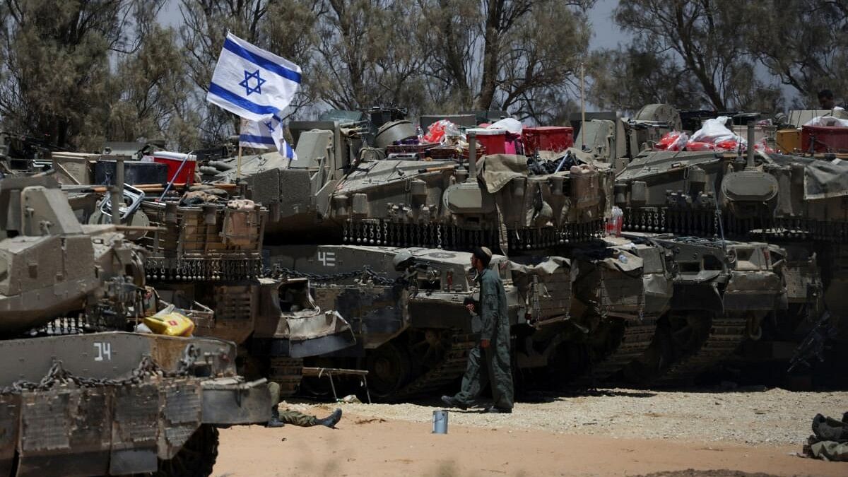 <div class="paragraphs"><p>An Israeli soldier walks near military vehicles, amid the ongoing conflict between Israel and the Palestinian Islamist group Hamas, near Israel's border with Gaza in southern Israel.</p></div>