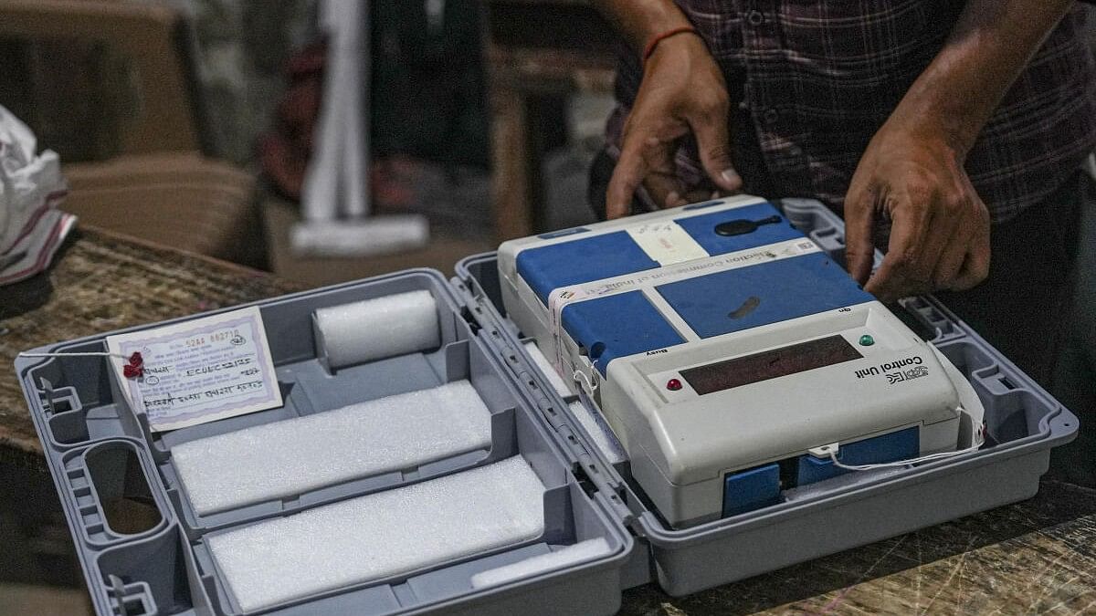 <div class="paragraphs"><p>A polling official prepares to seal the Electronic Voting Machine (EVM) at the end of voting during the third phase of Lok Sabha elections, at a polling station.</p></div>