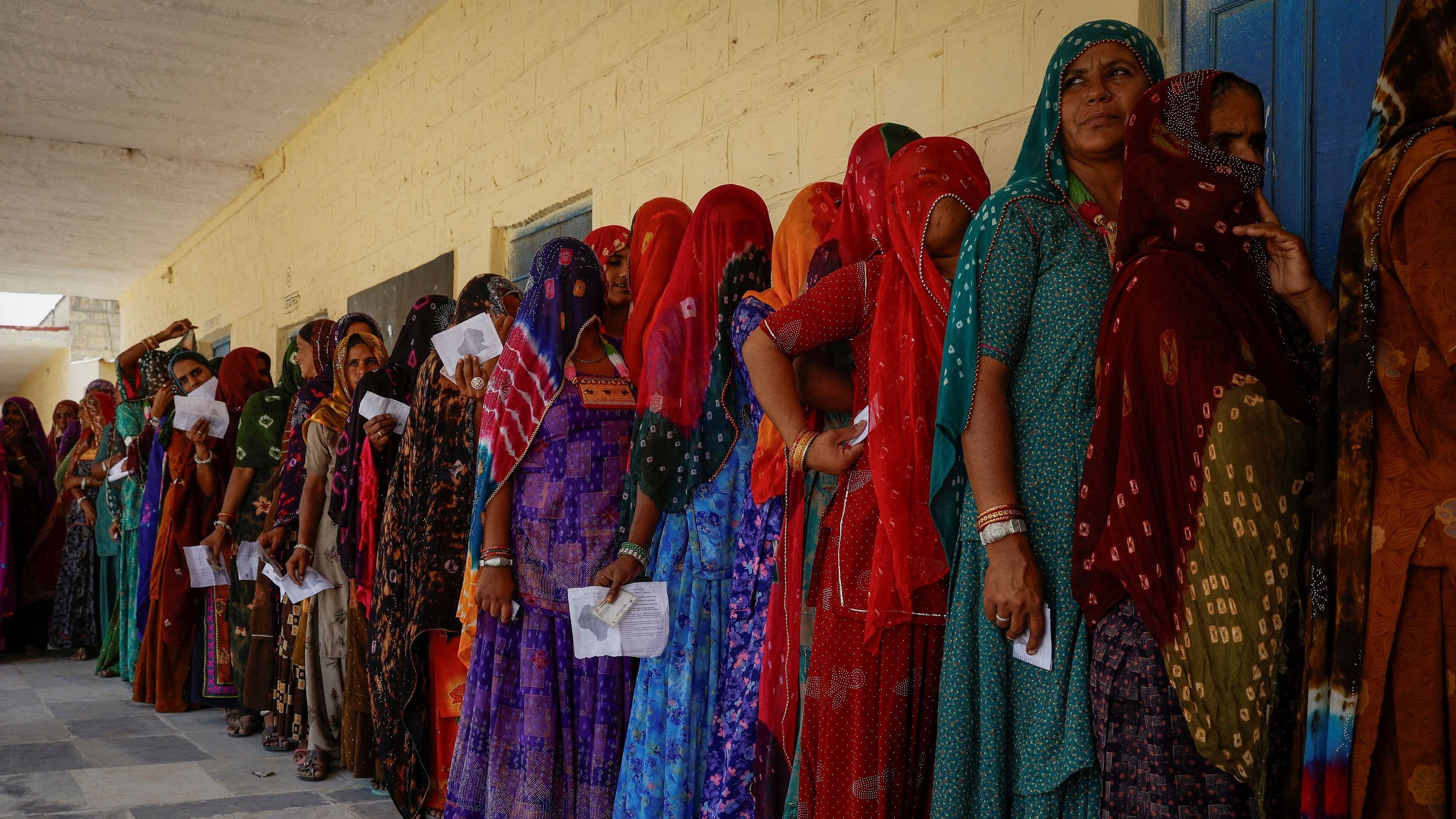 <div class="paragraphs"><p>Women stand in a queue to cast their vote at a polling station.</p></div>