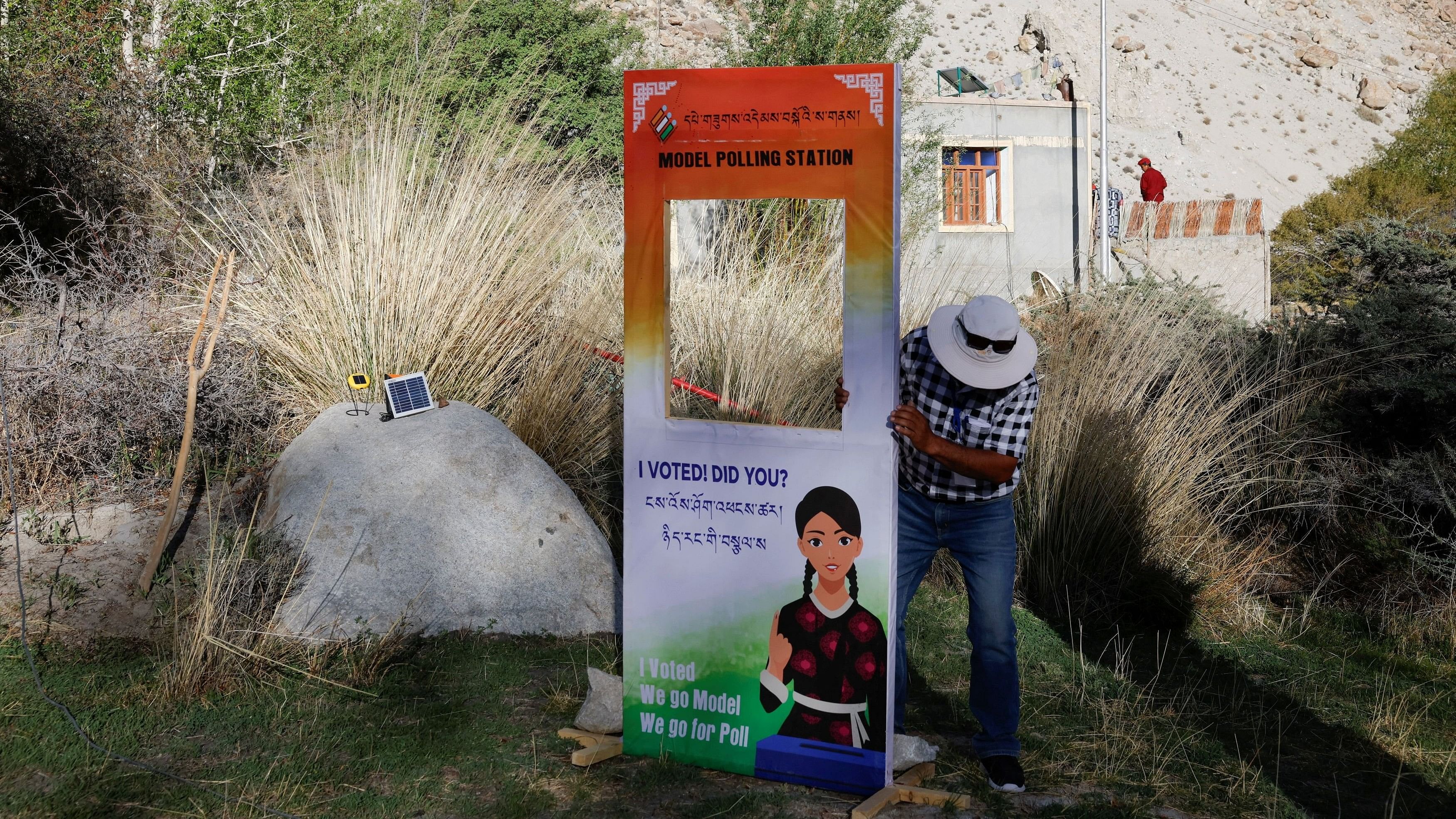 <div class="paragraphs"><p>Phonchok Stobdan, 57, a Booth Level Officer  fixes a board outside Ladakh's remote Warshi village, a polling station of five members, ahead of the fifth phase of the general elections, in the Ladakh region, India, May 19, 2024.</p></div>