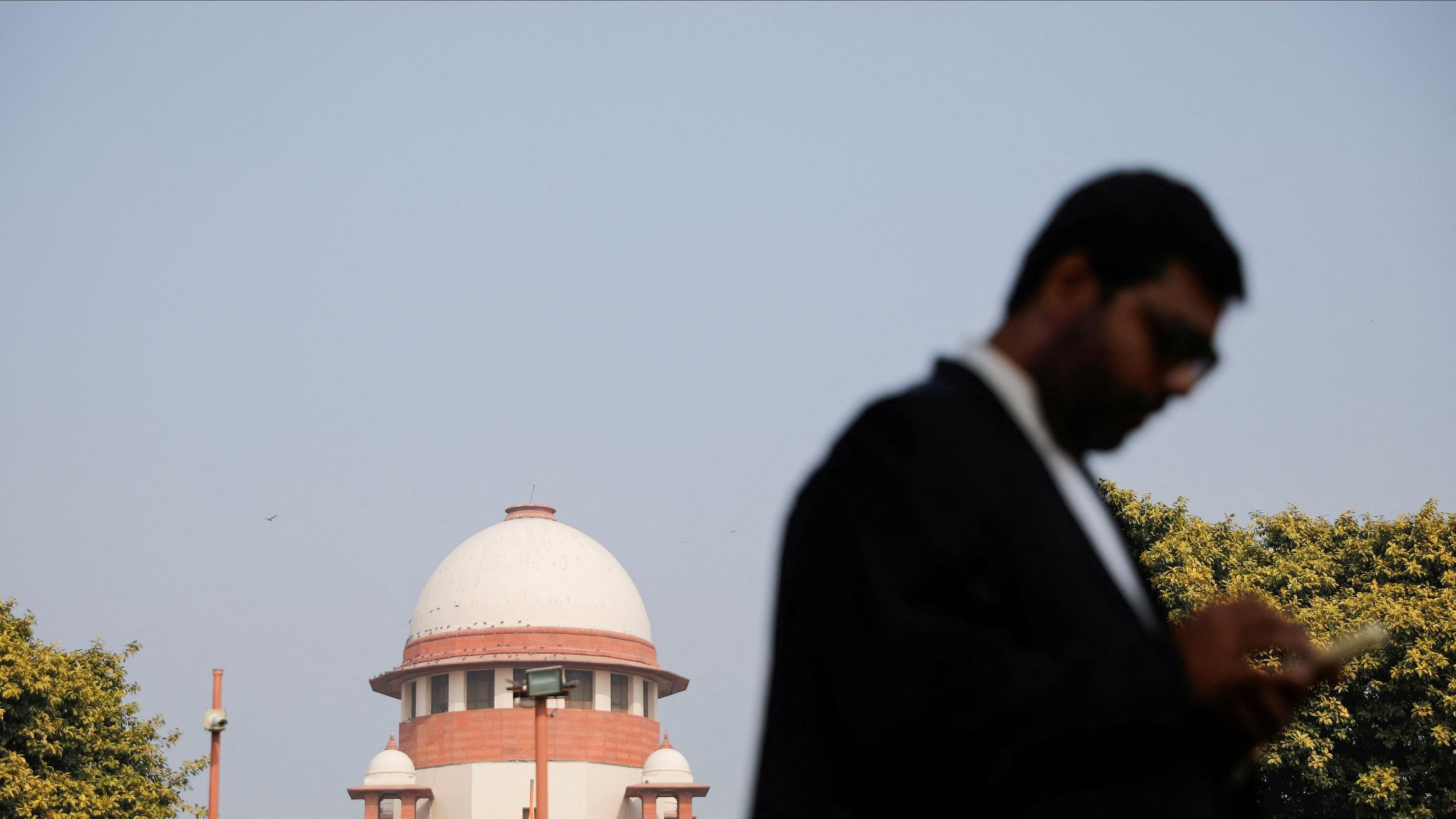 <div class="paragraphs"><p>A lawyer looks into his mobile phone in front India's Supreme Court in New Delhi.</p></div>