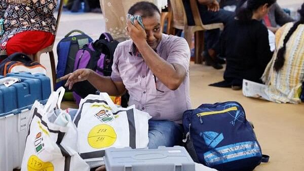 <div class="paragraphs"><p>A polling official wipes his face as he inspects election material at a distribution centre ahead of the fifth phase of India's general election, in Howrah district.</p></div>