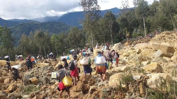 <div class="paragraphs"><p>People carry bags in the aftermath of a landslide in Enga Province, Papua New Guinea, May 24, 2024, in this still image obtained from a video. </p></div>