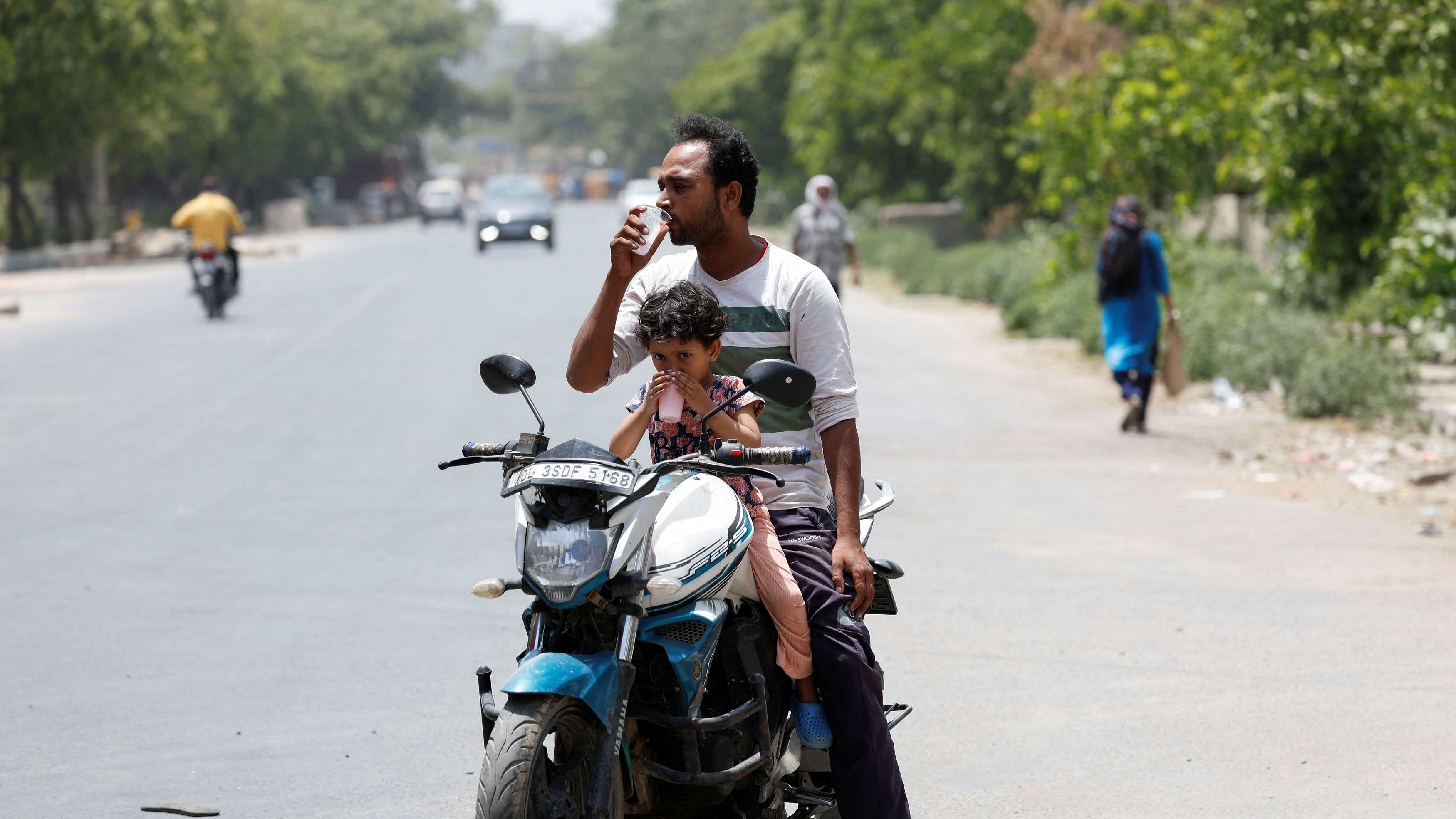 <div class="paragraphs"><p>A man and a child drink cooling drinks offered by locals on a hot summer day during a heatwave in Narela, New Delhi.</p></div>