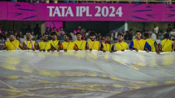<div class="paragraphs"><p>Ground staff carries covers on the ground as rain delays the Indian Premier League (IPL) 2024 T20 cricket match between Rajasthan Royals (RR) and Kolkata Knight Riders (KKR), at the ACA Stadium, Barsapara, in Guwahati, Sunday, May 19, 2024.</p></div>