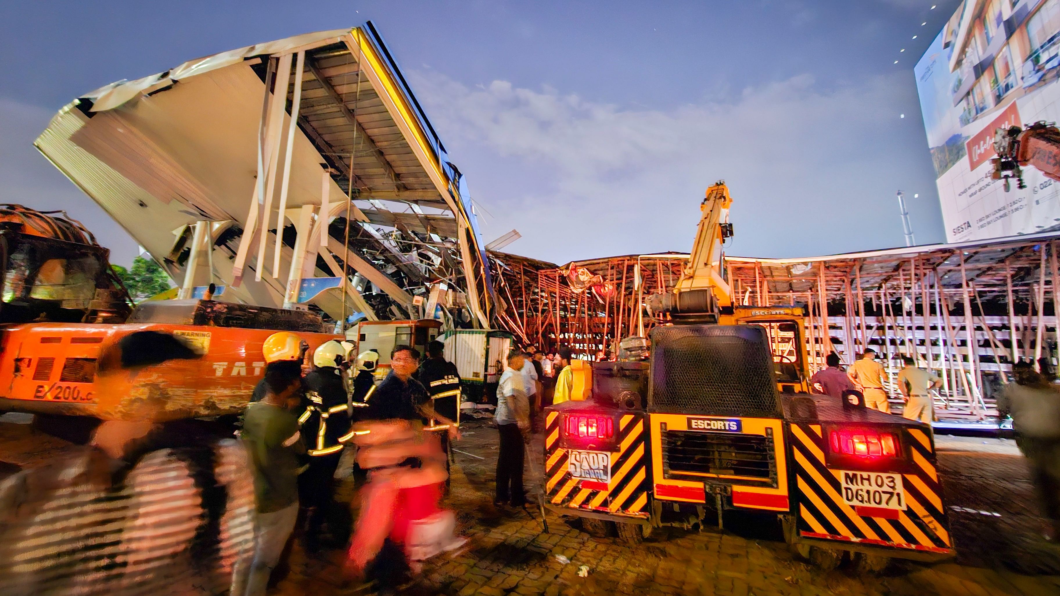 <div class="paragraphs"><p>Emergency services personnel at the spot after a huge iron hoarding collapsed on a petrol pump due to strong winds and heavy rain, at Ghatkopar in Mumbai, Monday.</p></div>