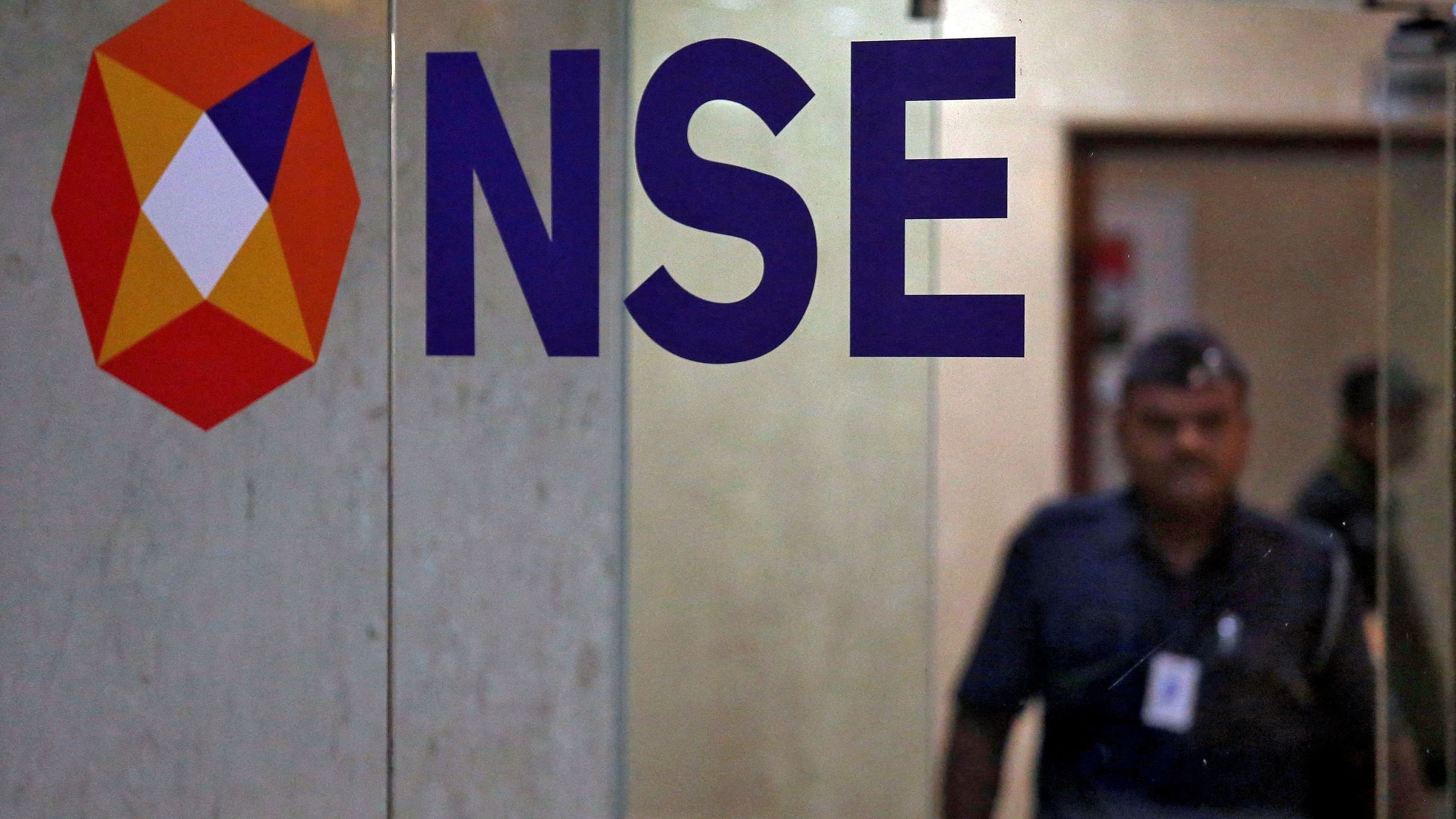 <div class="paragraphs"><p>A security guard walks past the logo of the National Stock Exchange (NSE) inside its building in Mumbai, India</p></div>