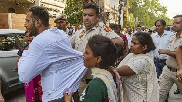 <div class="paragraphs"><p>Family members of victims attack Dr Akash as police brings him to the Baby Care Hospital where a fire broke out leaving seven newborns dead.</p></div>